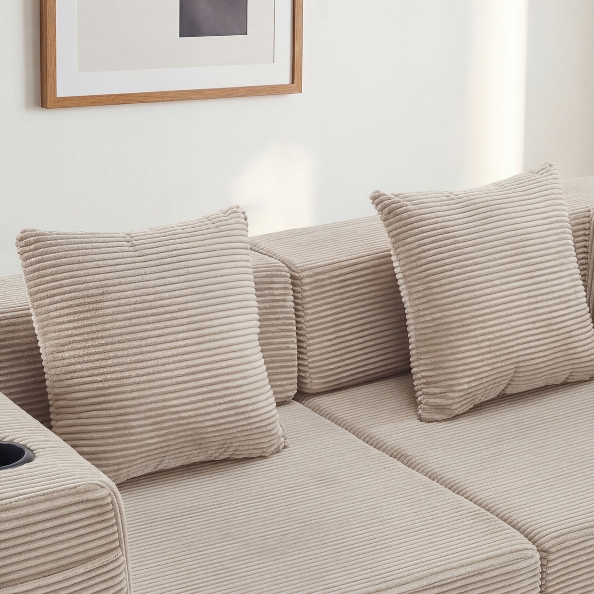 Canapé beige en velours côtelé, coussins épais et accoudoir rembourré