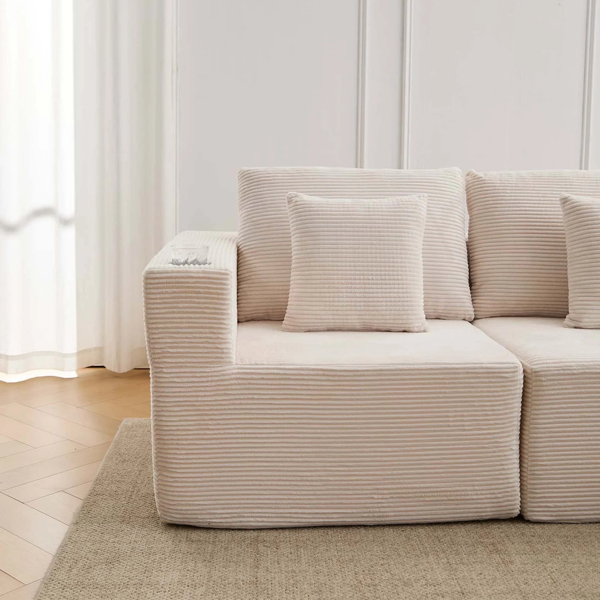 Canapé modulaire blanc cassé en tissu côtelé, assise et accoudoirs rembourrés