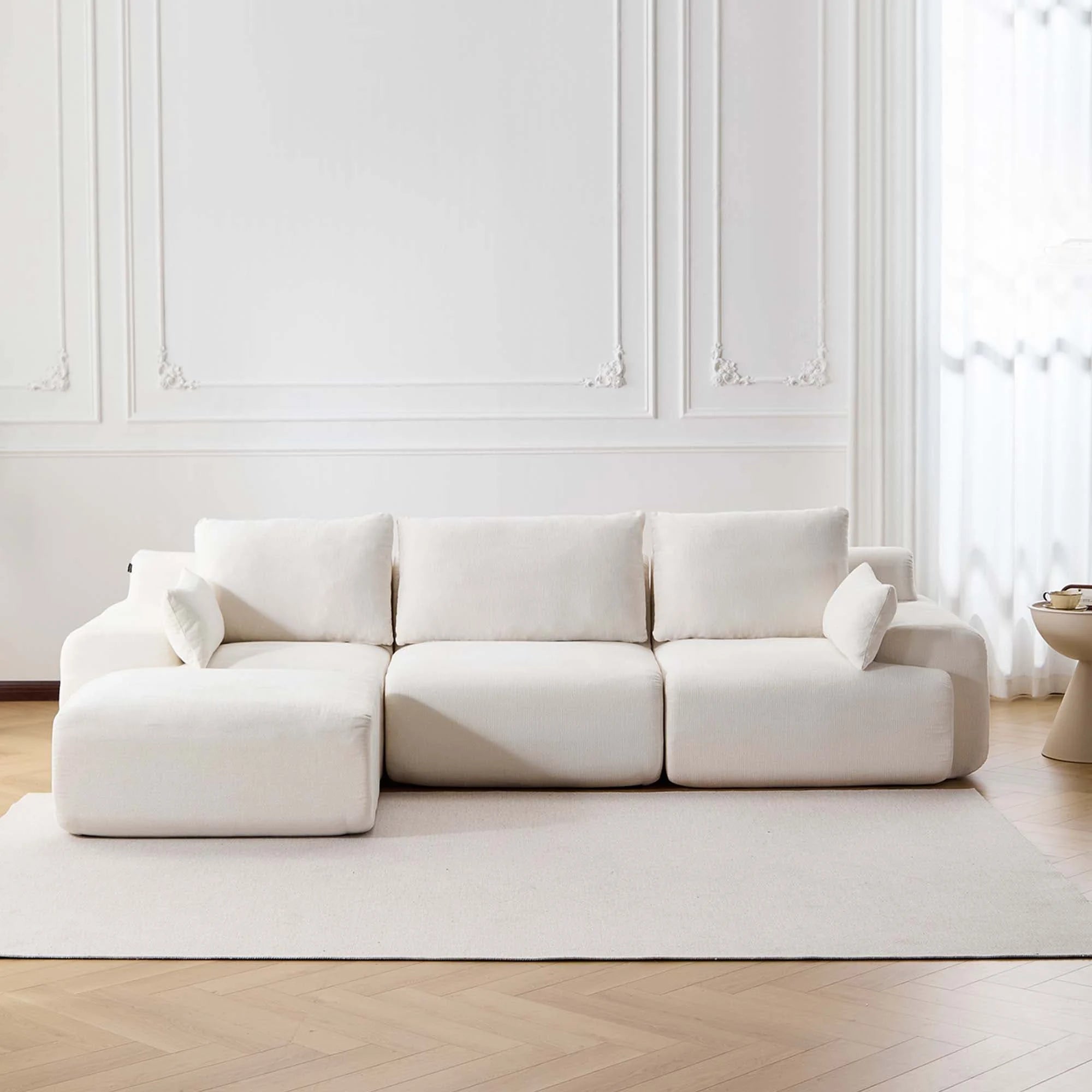 Canapé d’angle beige en tissu, 3 places, pouf intégré, sans boutons