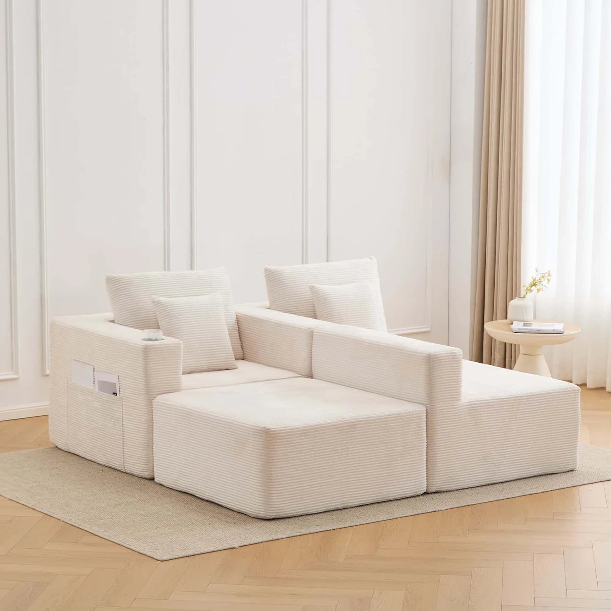Canapé modulaire blanc cassé en configuration d’angle, coussins et accoudoirs rembourrés