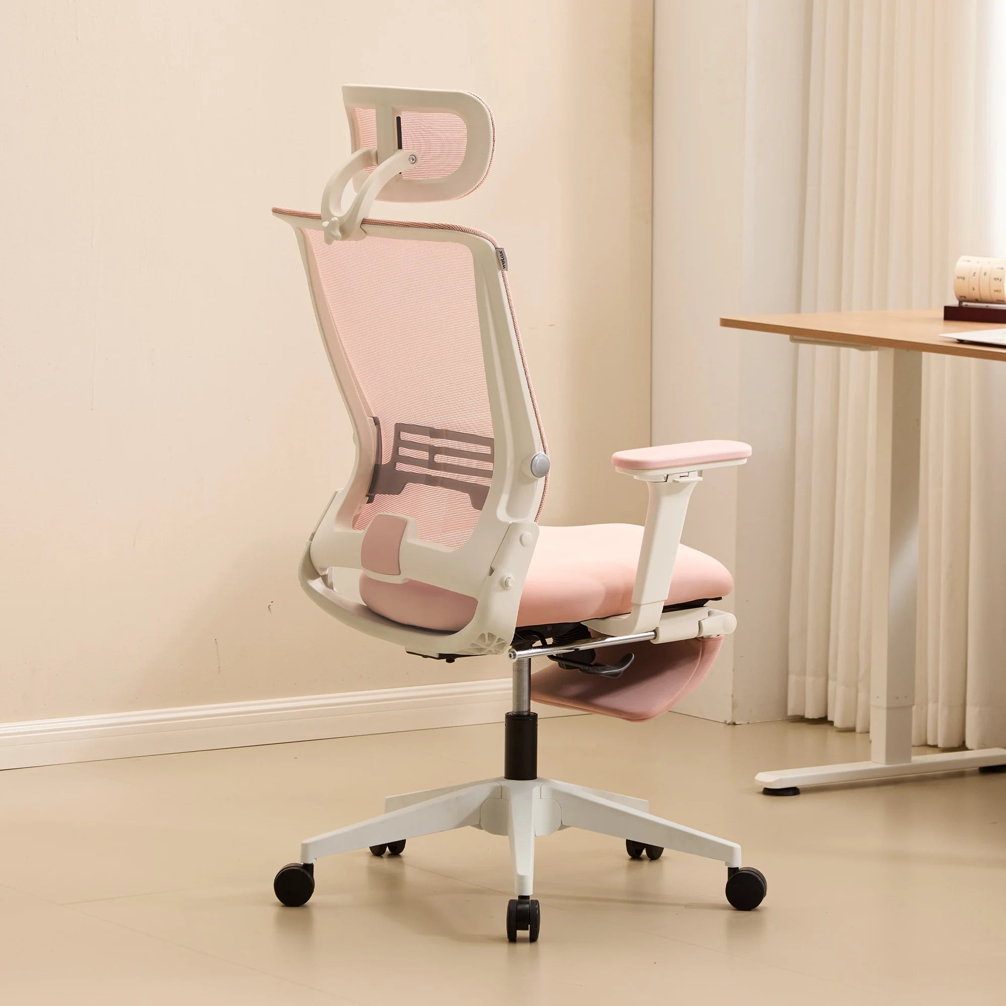 Chaise de bureau ergonomique rose, vue de côté, dossier rabattable et accoudoirs