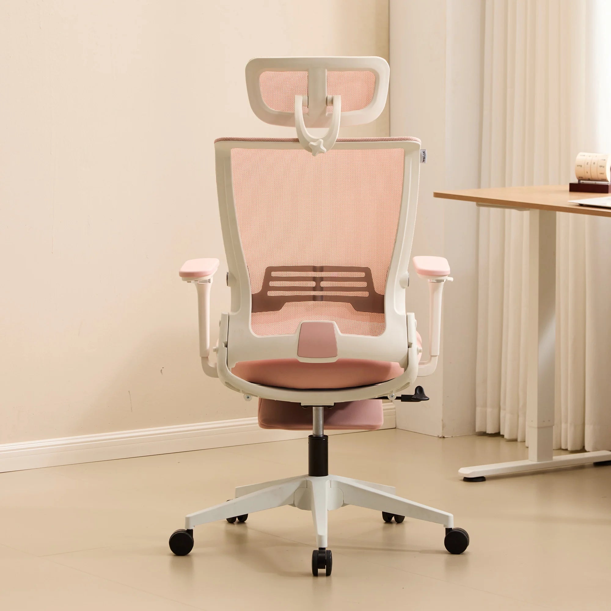 Chaise de bureau ergonomique rose, dossier ajouré et assise rembourrée, roulettes